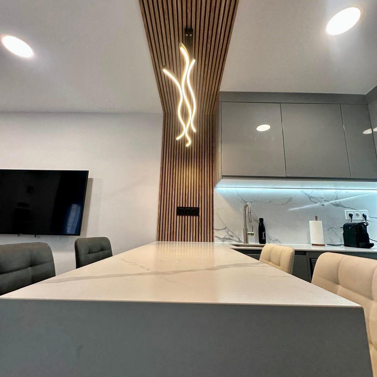 cocina gris moderna con encimera efecto mármol y barra integrada 2