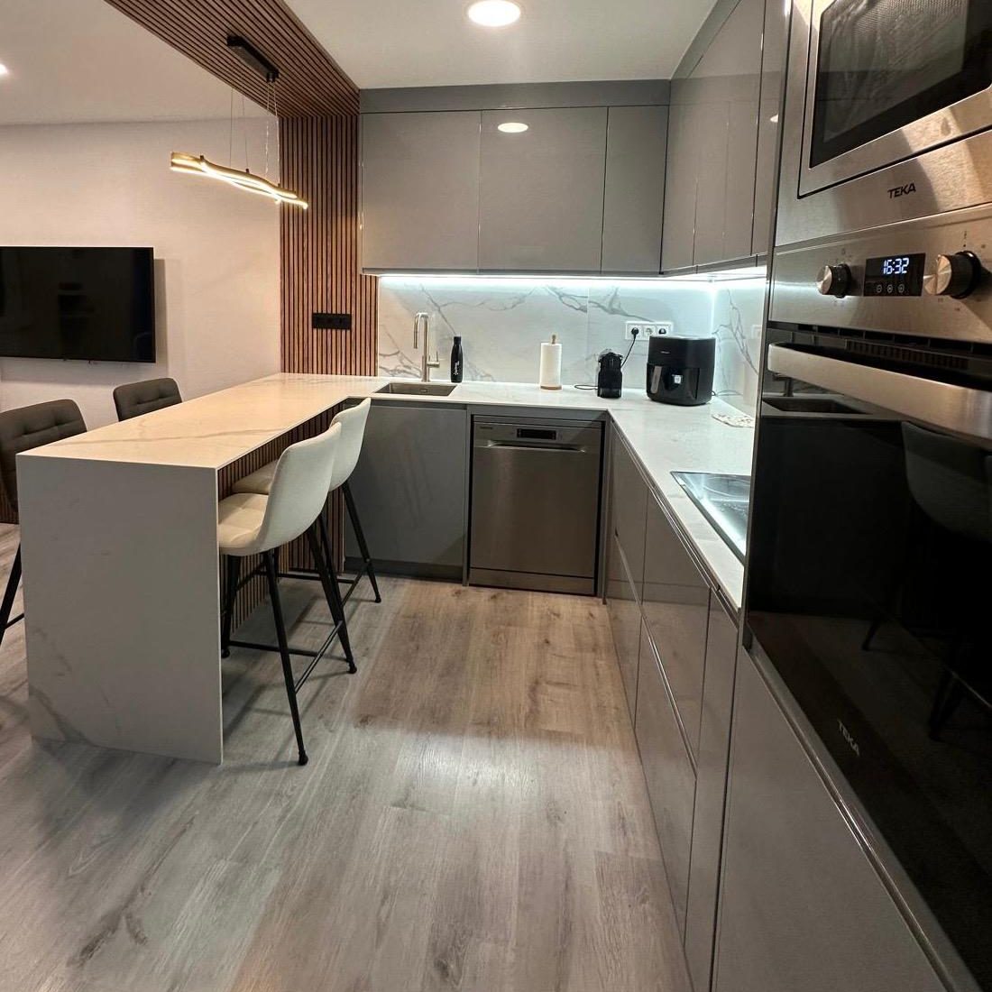 cocina gris moderna con encimera efecto mármol y barra integrada 4