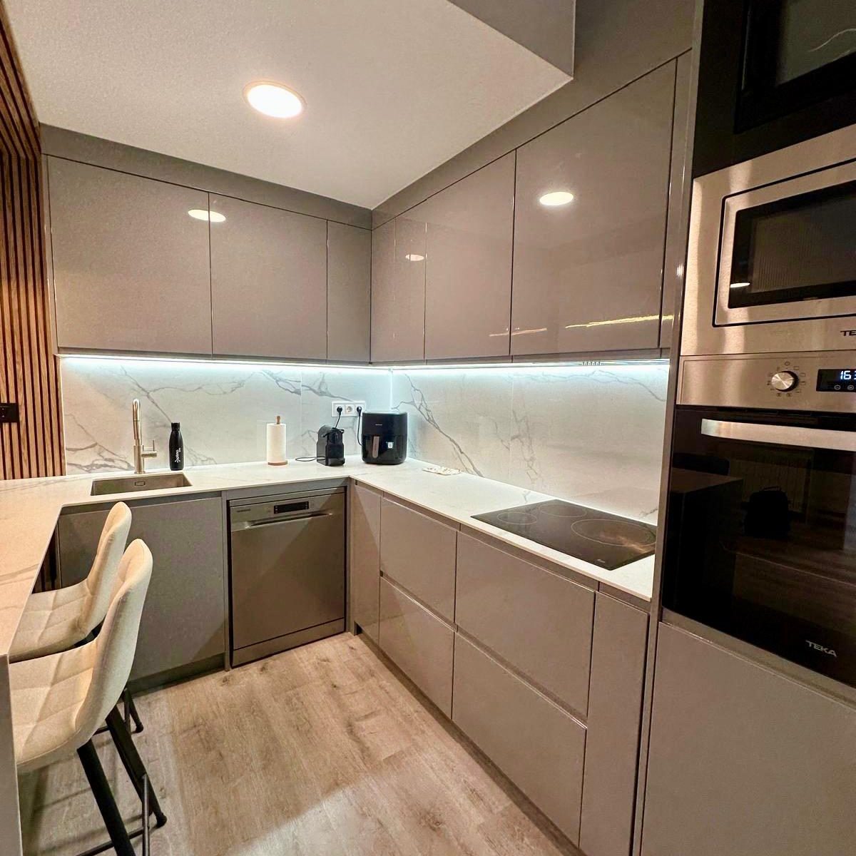 cocina gris moderna con encimera efecto mármol y barra integrada 5