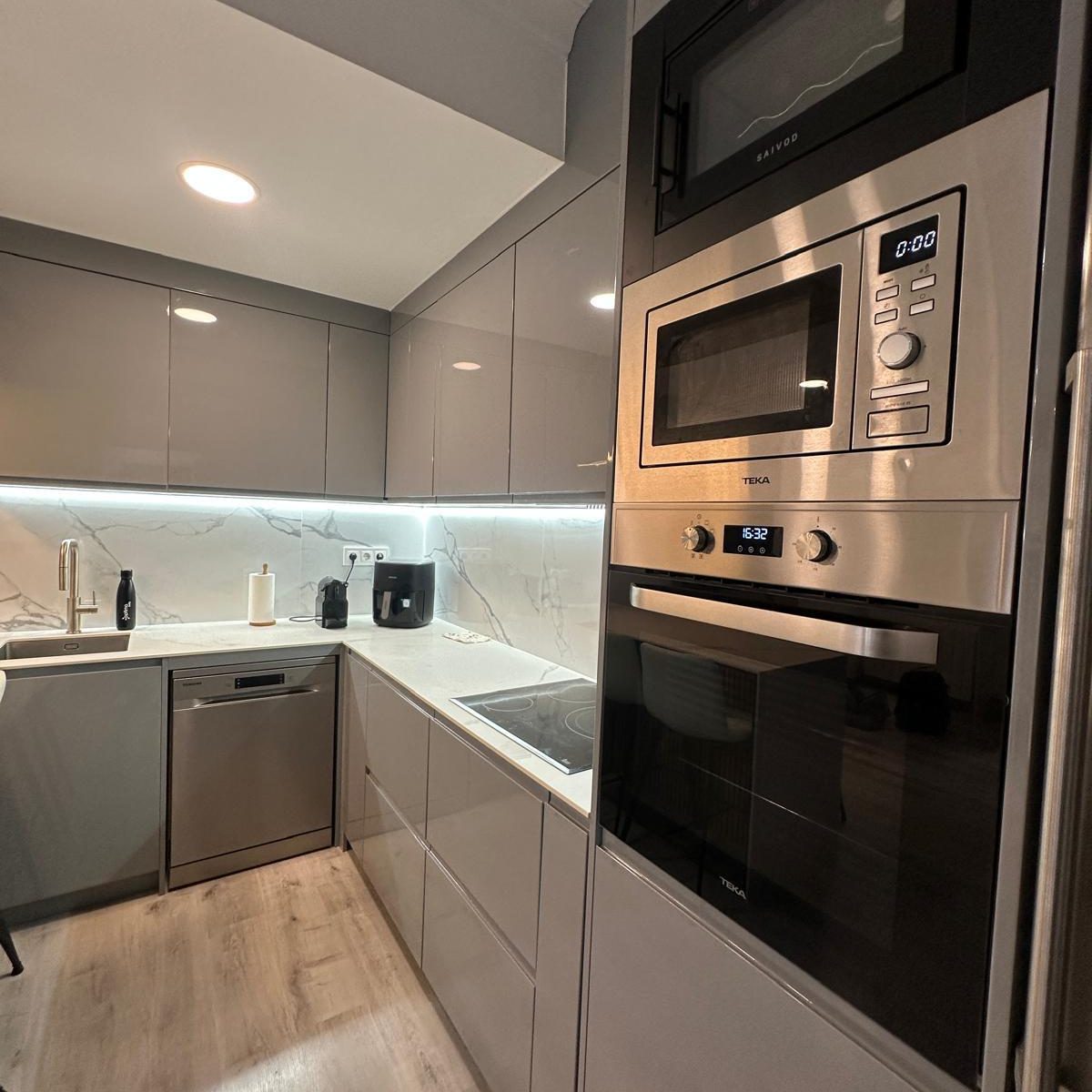 cocina gris moderna con encimera efecto mármol y barra integrada 1